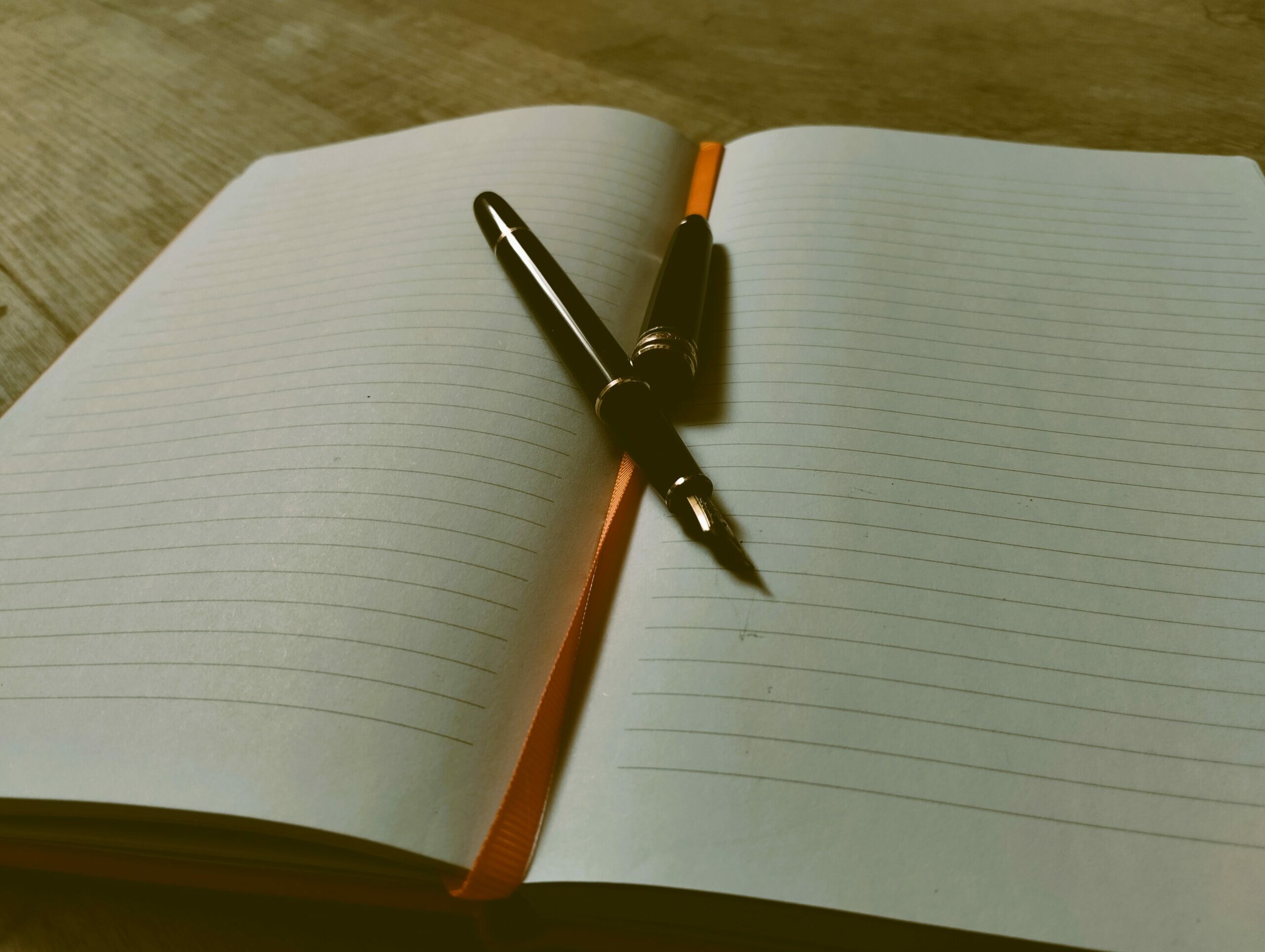 Une plume et un bloc note pour écrire un article